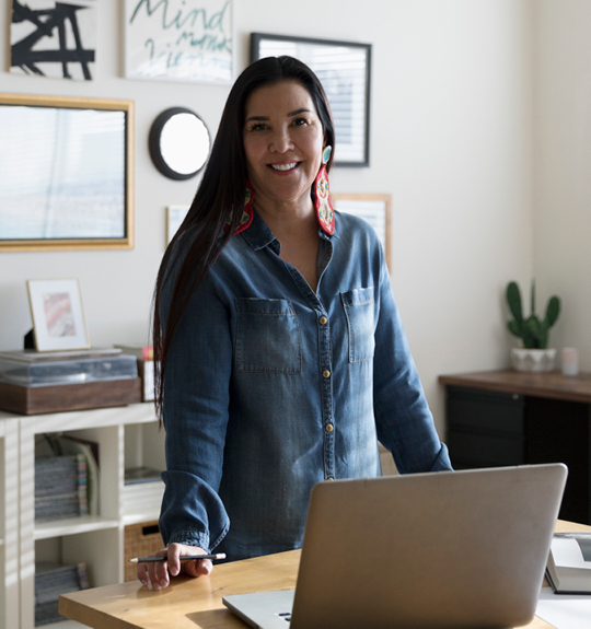 woman standing in her office with a pencil in her hand