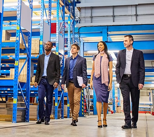 businesspeople walking through a warehouse