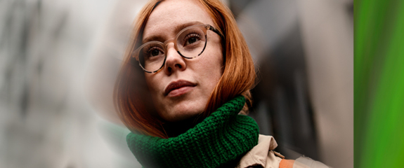 Femme rousse avec des lunettes portant un foulard vert