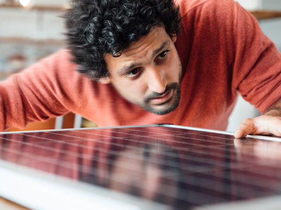 man looking at a small solar panel