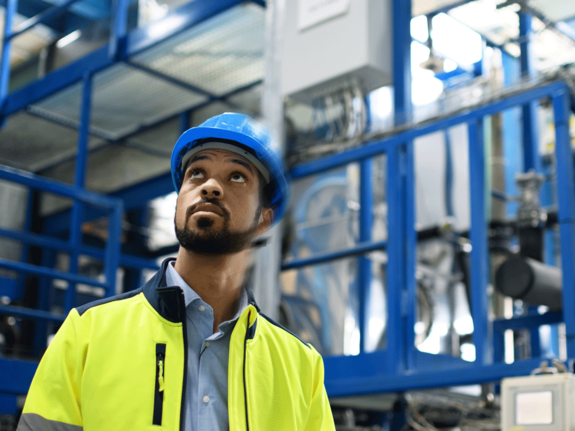 man in yellow vest working in a factory