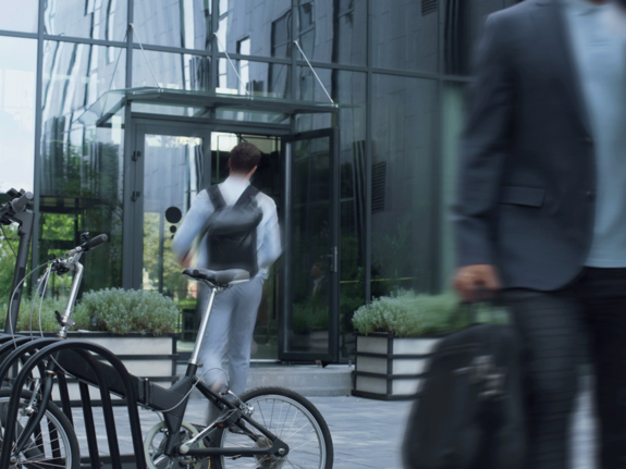 homme garant son vélo à côté du bureau