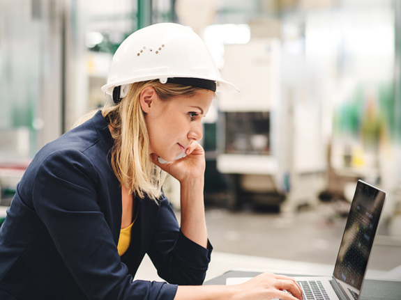 businesswoman in a hard hat working on optimizing her supply chain