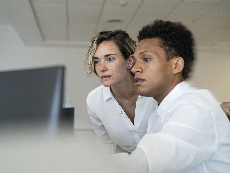Two colleagues discussing content on a screen